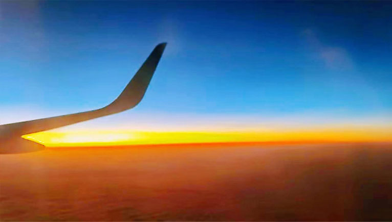 photo of airplane wing and sunset skies