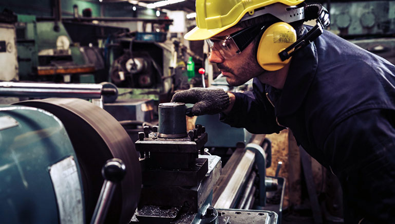 man in hard hat working on machinery